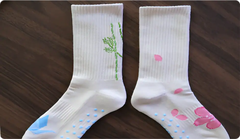 Comfortable white socks with pink and blue floral designs, featuring textured patterns and soft fabric, ideal for knitting enthusiasts and sock lovers.