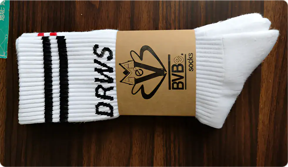 White athletic socks with black and red stripes, branded "DRYUS" and "BVB" logo, designed for sports and active wear.