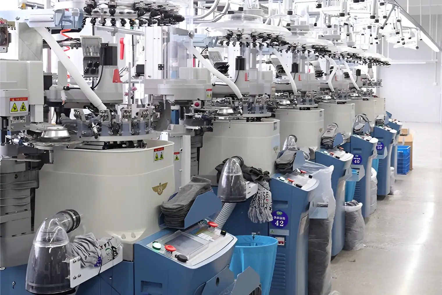 High-tech knitting machines in a modern factory setting.